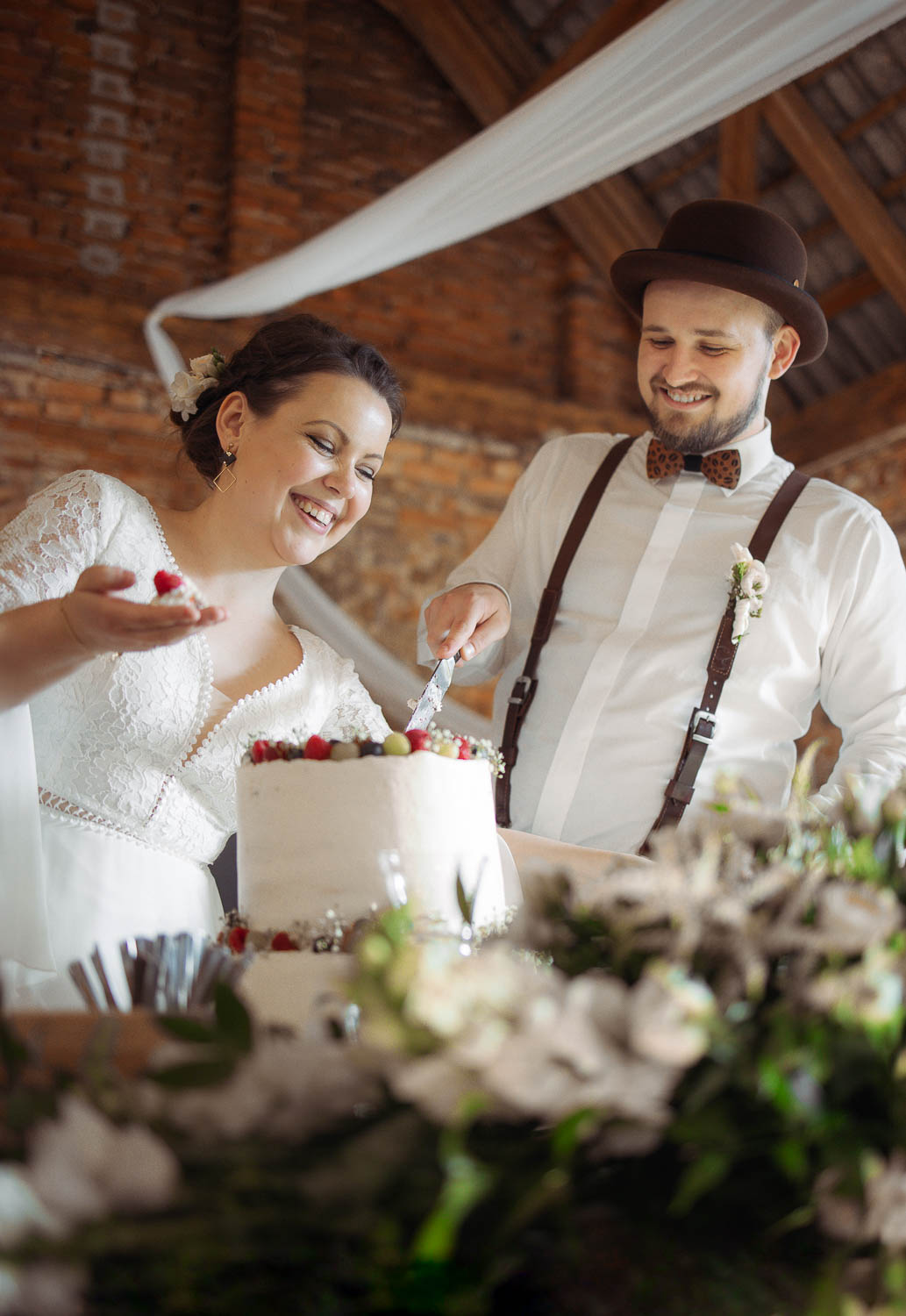Nevěsta a ženich rozkrajují svatební dort.